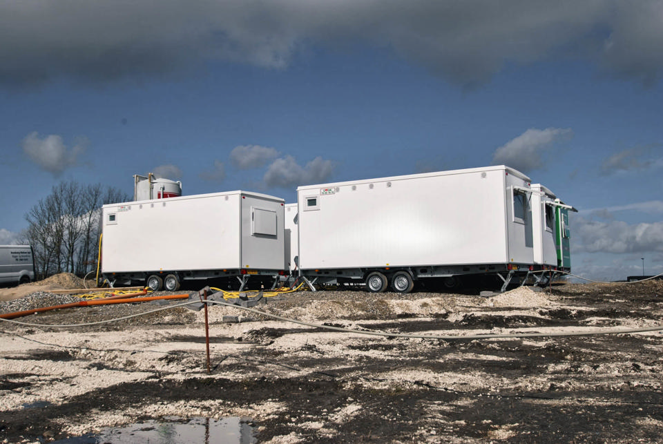 Tre godik mandskabsvogne på en byggeplads