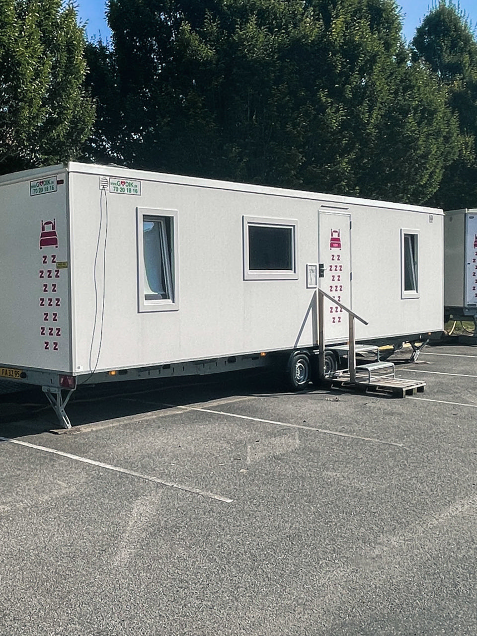 En stor Godik beboelsesvogn på en parkeringsplads ved en boligblok