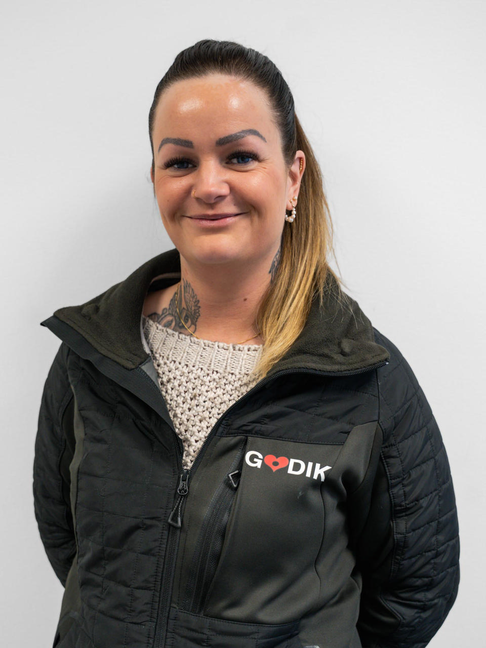 En smilende Godik medarbejder med kommunikationsudstyr