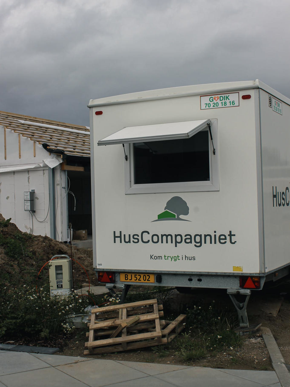 En godik mandskabsvogn foran et byggeri