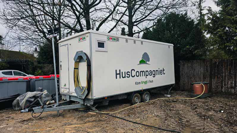 En godik mandskabsvogn med HusCompagniet folieret branding på gavlen