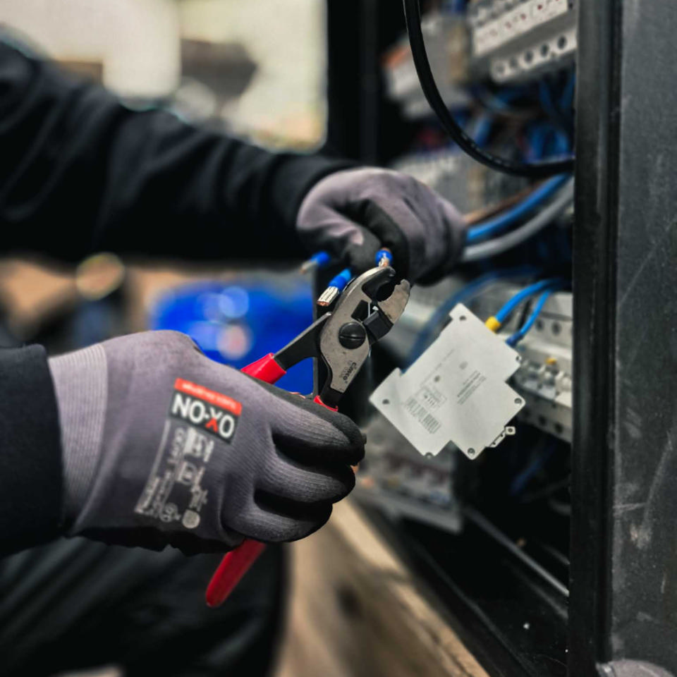 Godik tilpasser kabler i en eltavle